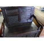 Carved dark oak hall bench with four carved panels to the back, lift up box seat and three further