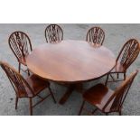 Quality medium oak circular dining table and a set of six wheelback dining chairs on turned supports