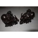 Pair of Chinese carved hardwood figures riding water buffalo with inlaid white metal detail and