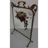 Art Nouveau brass framed fire screen, the bevelled edge mirror panel with painted floral detail