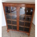 Walnut bookcase enclosed by two glazed cupboard doors (91cm x 31cm x 121cm)