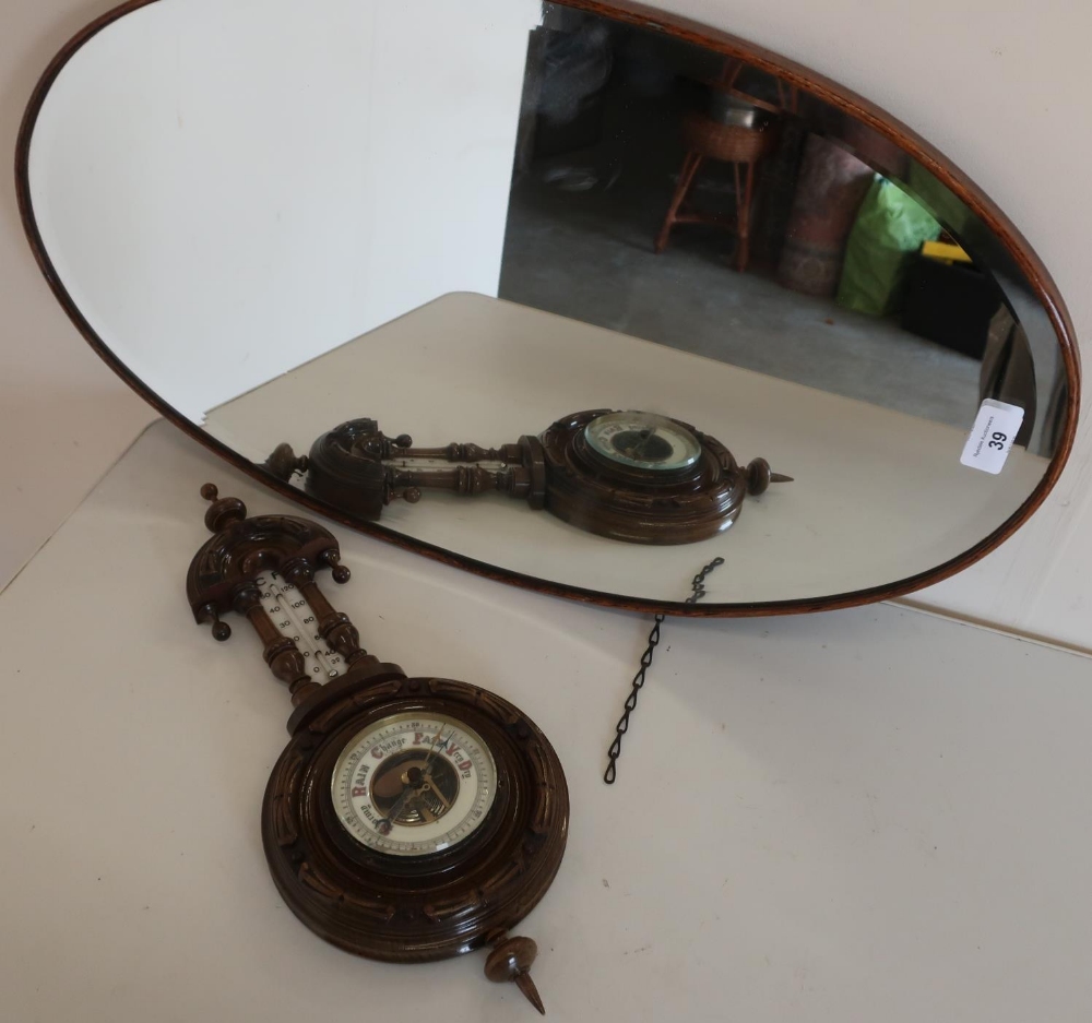 Oval oak framed bevelled edge wall mirror and a carved oak framed wall barometer (2)