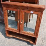 Waxed pine wall cupboard enclosed by two mirror panelled doors, above open shelf (64cm x 16cm x