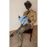 Composite figure of a suited gentleman, seated and reading, sat upon a Victorian mahogany dining