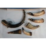 Collection of six various cows horn powder flask, one with Eastern brass mounts