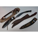 Decorative kukri knife with horn grip and scabbard with brass inlaid detail, another kukri leather