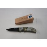 As new Elk Ridge folding knife, 1/4 inch black blade with pictorial handle