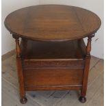 Carved medium oak monks chair with circular tilt top with carved panel and lift up box seat, on
