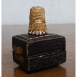 Victorian gold plated thimble with seed pearl and scroll decoration, in fitted box