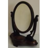 Victorian mahogany toilet mirror, with oval mirror plate on curved supports and serpentine base