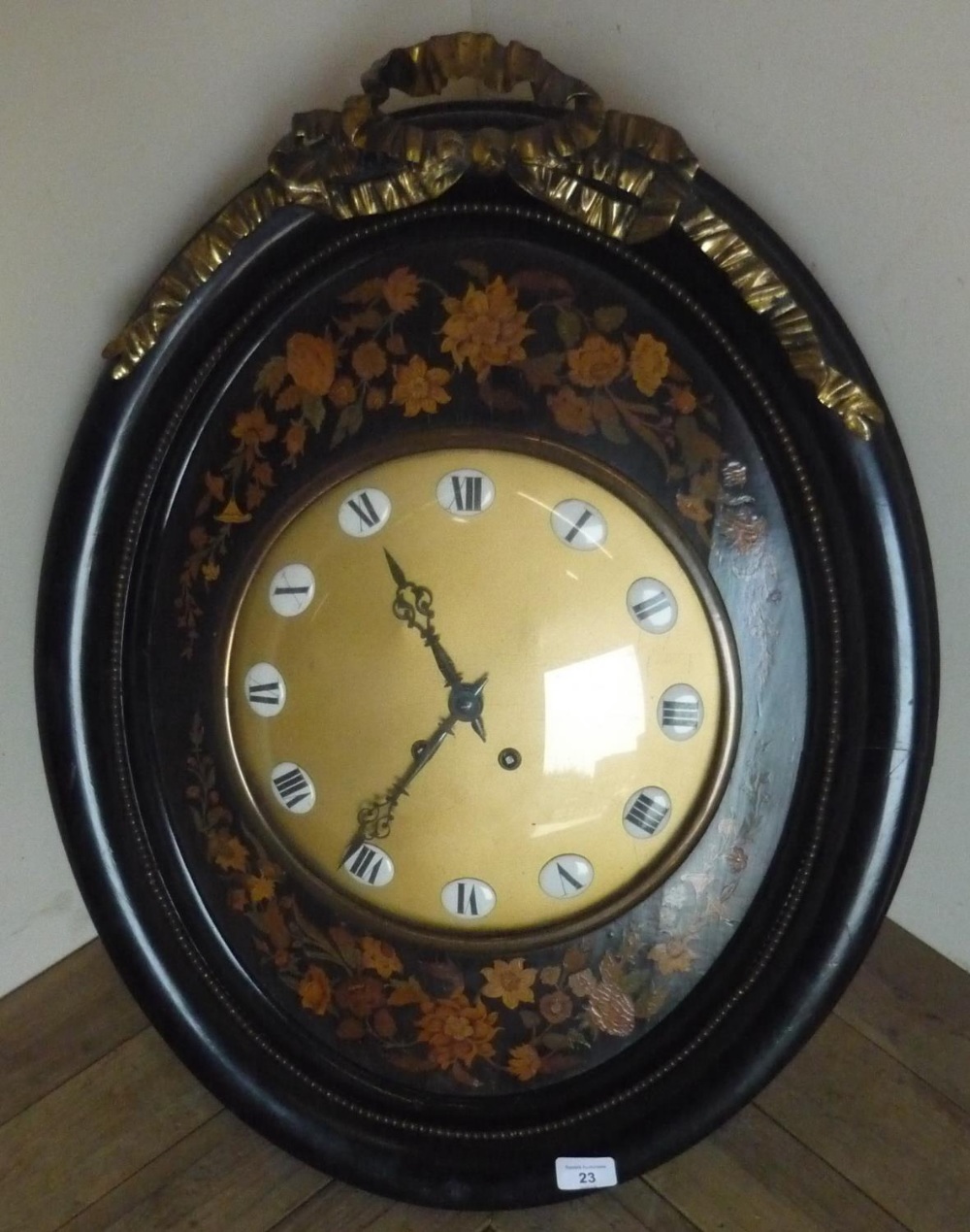 Large 19th C oval ebonised framed wall clock with gilt painted dial and white porcelain numbers,