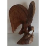 Large carved wood figure of an eagle, wings outspread, on branches, with two birds to the base (51cm