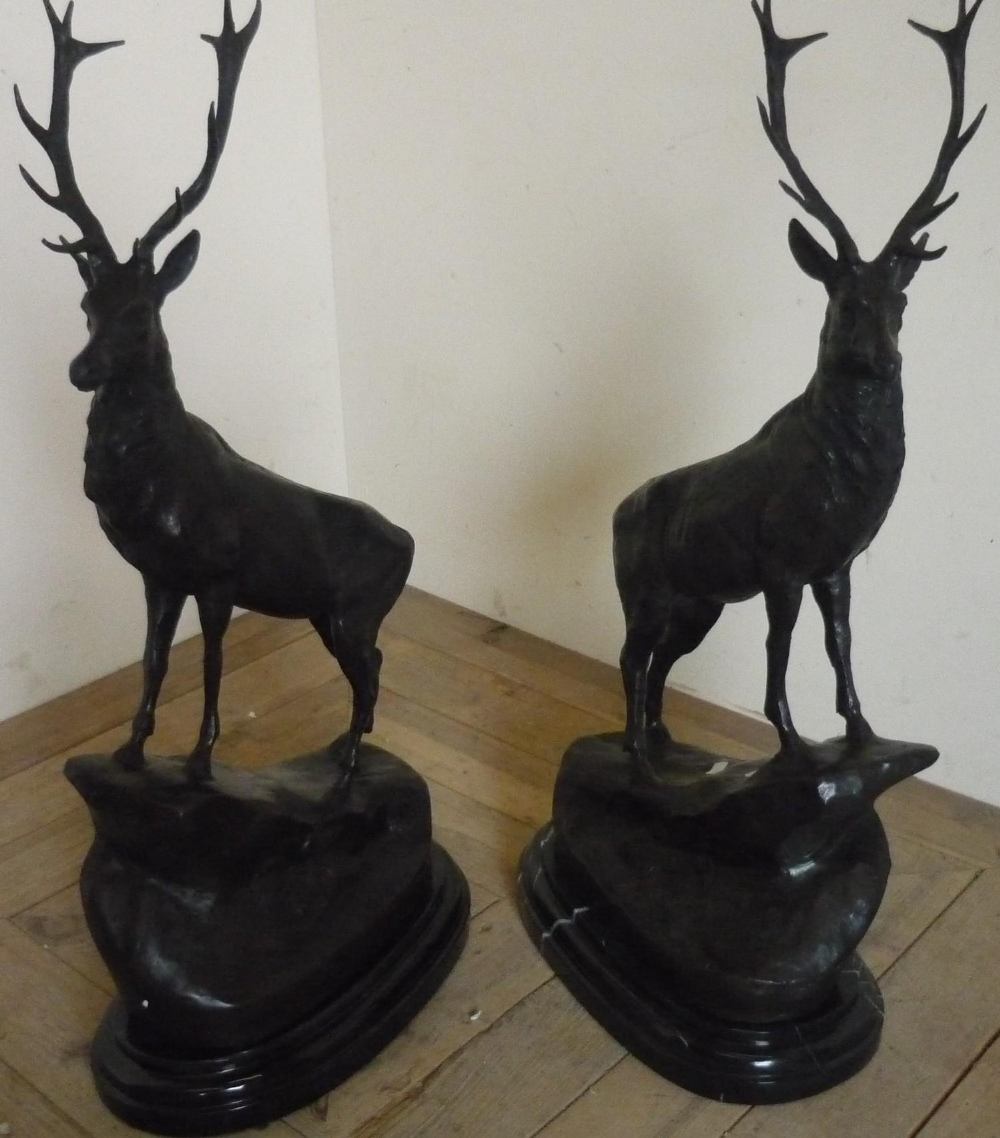 Pair of bronzed stags on rocky outcrop,on oval stepped marble bases (75cm)