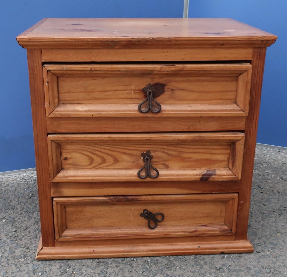 Rustic waxed pine chest of three short drawers with scrolled metal handles (61cm x 61cm x 43cm)
