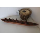 Carved African native canoe with various figures and a tribal leather drum (2)