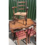 Oak extending drawer leaf table on trestle base, a set of four matching ladder back chairs and a