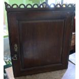 George III oak wall cabinet with pierced arch frieze, and fielded panel door enclosing two