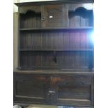 20th C oak dresser, twin shelf planked back with cupboard, the base with two paneled doors on