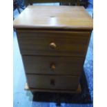 Pine three drawer bedside chest, rectangular occasional table and pine stool (3)