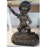 Tibetan style bronze figure of a dancing deity with headdress, stood upon a figure of a naked