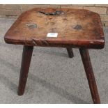 19th Century elm "cutlers" stool, shaped rectangular top on three faceted pegged supports, stamped