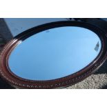 Large bevelled edge mahogany framed oval wall mirror (69.5cm x 100cm)