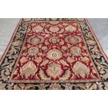 20th C traditional wool rug with central floral pattern field and stylised floral boarder (330cm x