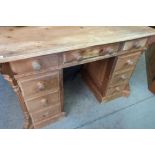 Pine writing desk with rectangular top over nine drawers with turned wooden handles (122cm x 80cm