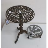 Victorian brass trivet with pierced circular top on tri-pod base (32cm high) and another brass
