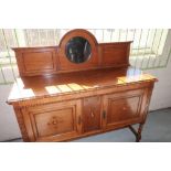 1930s oak sideboard, the raised arched back with circular bevelled mirror, pie crust carved top