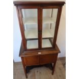 Early 20th C mahogany display cabinet, glazed all round with two shelves, the base with two doors,
