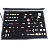 Modern glazed top display case containing a selection of various costume style dress rings,