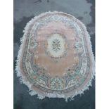 Oval Chinese embossed washed woollen rug, pink ground with central floral medallion and floral