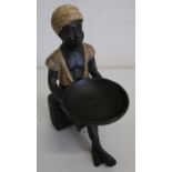 Painted cast metal figure of an Eastern boy, seated on a case holding a large bowl (height 20cm)