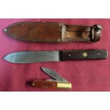Vintage skinning knife with 5 inch steel blade, with wooden grip in leather sheath, and a twin