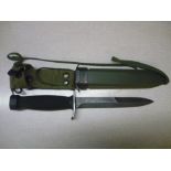 Military style combat knife with 6 1/2 inch blade with double edged point, checkered composite grip,
