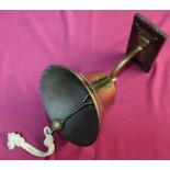 Modern brass hanging ships type bell with clanger, mounted on to rectangular wooden wall plaque,