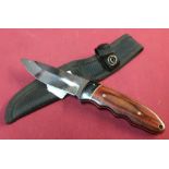 4 inch bladed sheath knife with working back detail and two piece wooden grip complete with webbing