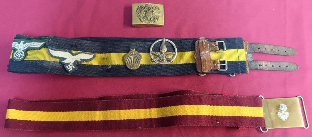 Two stable belts, one with brass buckle, a Russian brass belt buckle and various badges mounted to