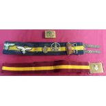 Two stable belts, one with brass buckle, a Russian brass belt buckle and various badges mounted to