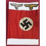 German WWII Swastika car pennant, two similar armbands and two embroidered lapel badges (retrieved