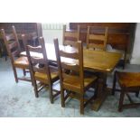 Oak dining table with trestle ends and a set of six ladder back rush seated chairs