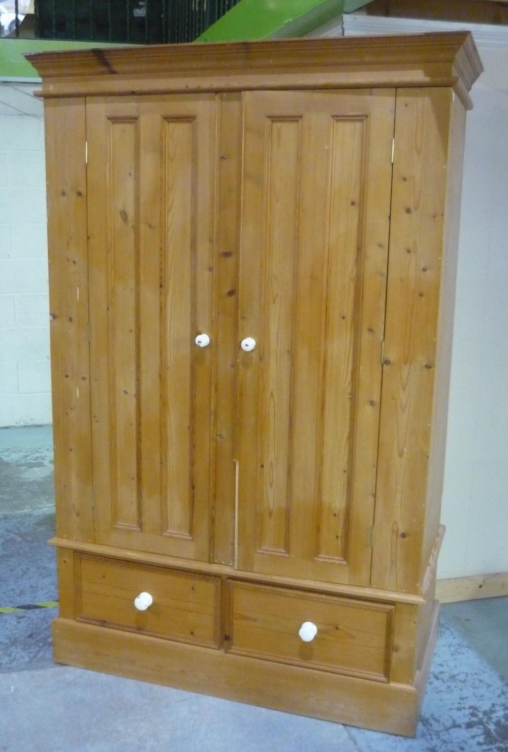 Pine wardrobe enclosed by two panelled doors over two drawers, with molded cornice (194cm x 63cm x