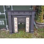 Wood fire surround decorated with swags, and a cast fireplace with flower design and tiles