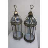 Pair of brass six panel floor lanterns with domed tops, brass loop handles, on scroll feet (height