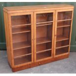 1940s walnut bookcase with three glazed doors and adjustable shelves on a plinth base (122cm x 108cm