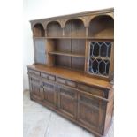 Oak Priory style dresser with raised back, and two cupboards enclosed by lead glazed cupboard doors,