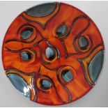 Large Poole pottery circular dish, decorated in the Peacock pattern on a burnt orange ground, (