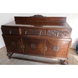 c.1930's oak sideboard with raised back, above three short drawers with elaborate carved detail,