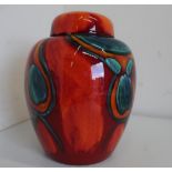 Large Poole pottery ginger jar and cover, decorated in the Peacock pattern, on burnt orange